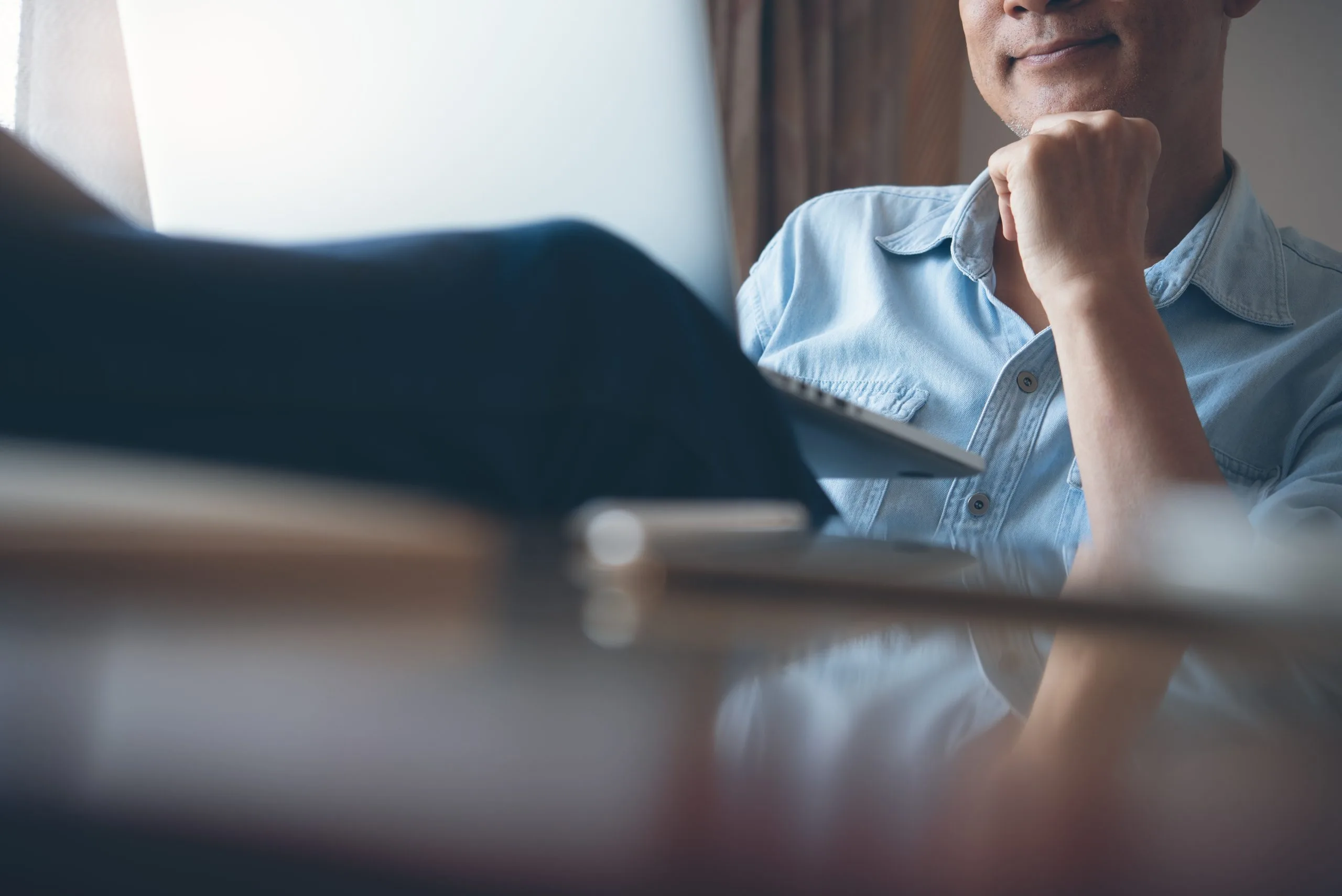 Smiling middle age casual business man, freelance relax working on laptop computer at home. Happy asian freelance man sitting on sofa networking, home office concept, close up